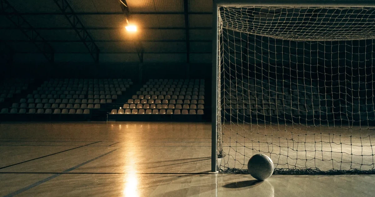 Ein Tor mit dicht gespanntem Netz steht in einer grossen Halle, davor liegt ein Handball auf der Torraumlinie.