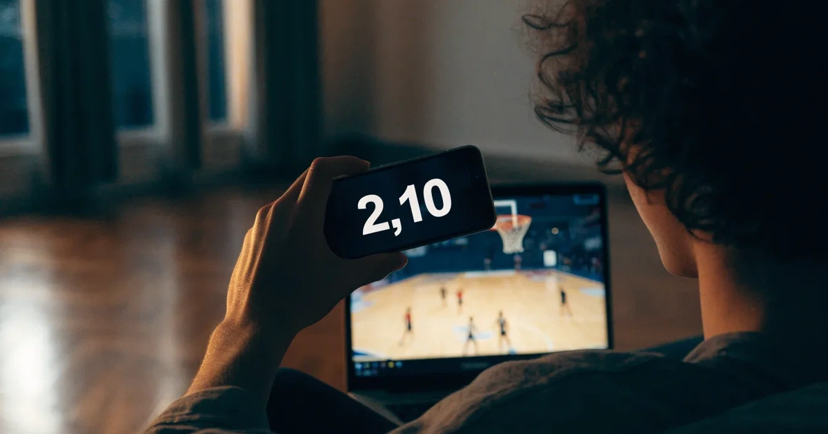 Ein Basketballkorb in einer leeren Halle, der Parkettboden glänzt im Licht der Deckenlampen